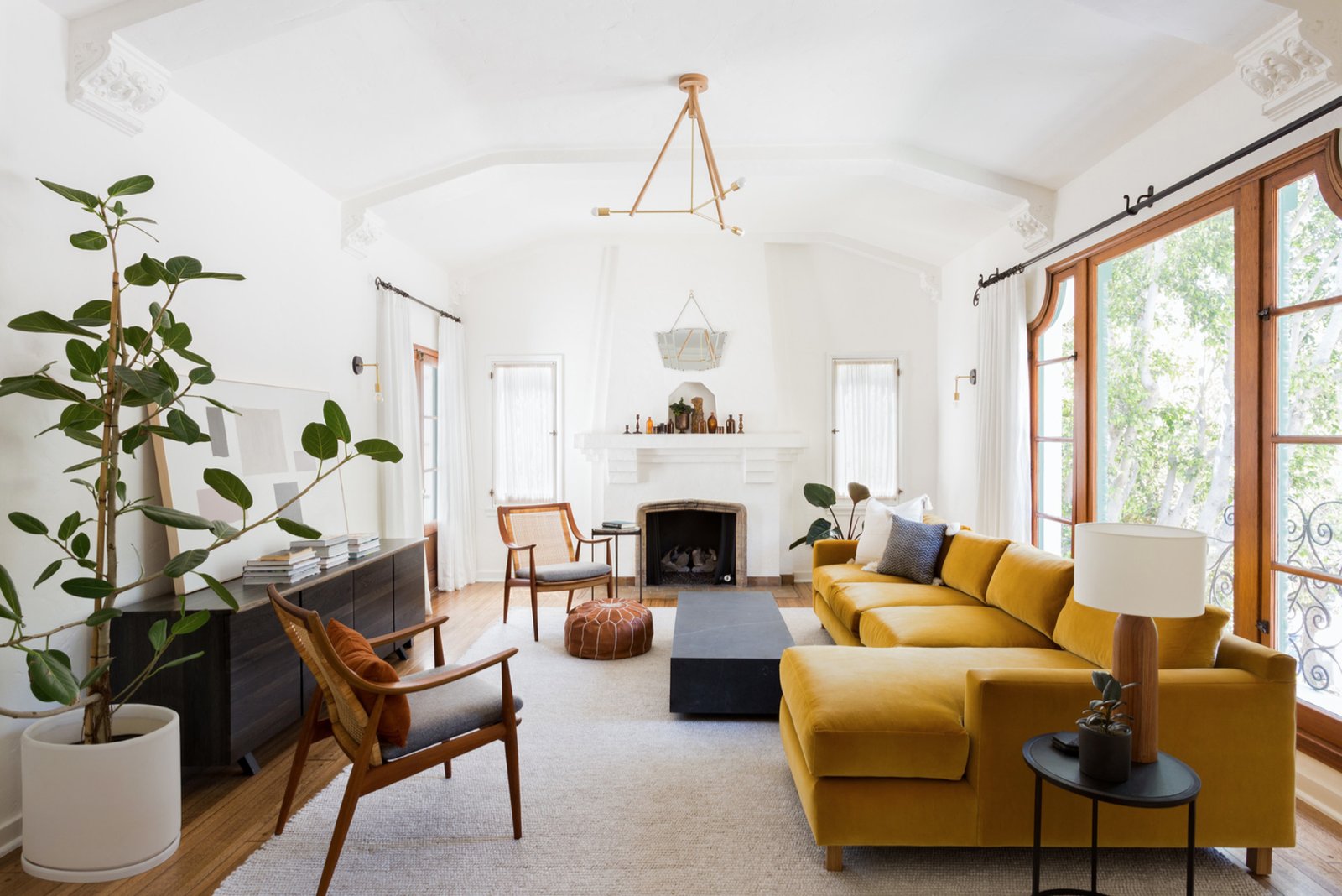 Long narrow living room divided into two seating zones with area rugs